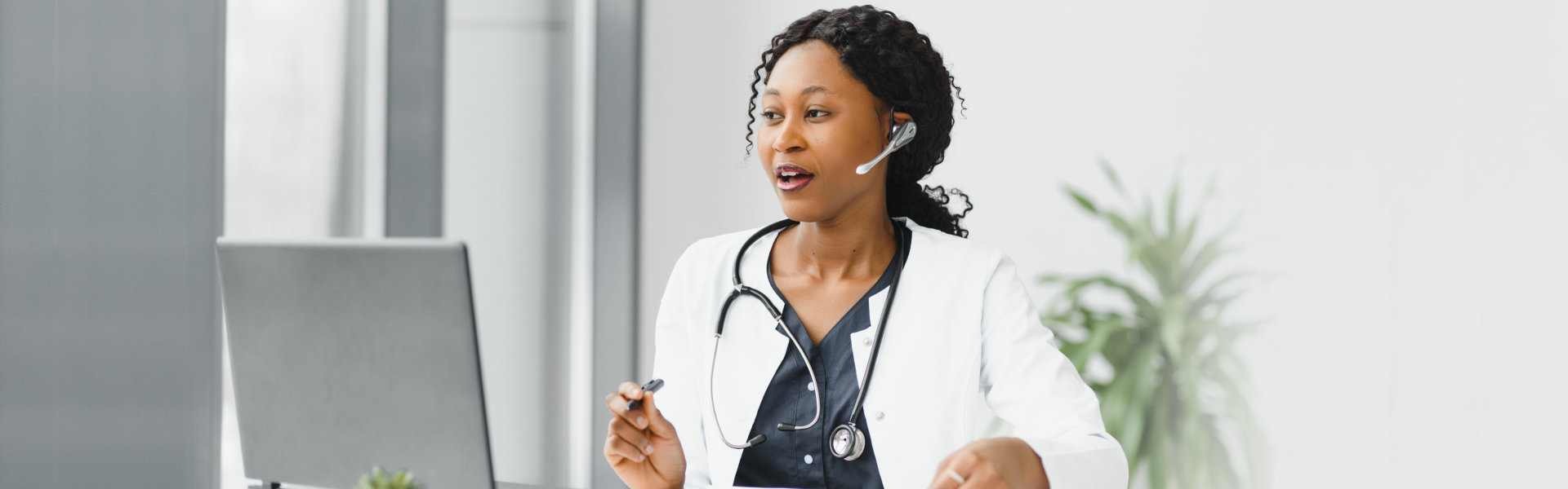 A female doctor wearing a headphone and looking at to a computer
